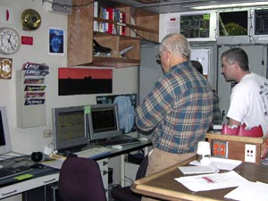 Mike Carpenter (right) and Larry Madin watch the readout of a midnight MOCNESS net tow (left monitor) in the E-lab. (Photo by K. Madin, WHOI)