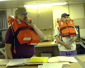 Co-Chief Scientists Jim Cochran (left) and Dan Fornari listen to the safety presentation in the Main Lab during the fire and boat drill.
