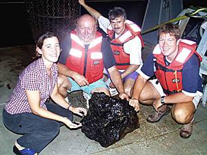The dredge team (from left, Clare Williams, Ron Comer, Dan Fornari and Ben Wigham) last night hauled up a “monster” pillow basalt rock that completely filled the mouth of the dredge!