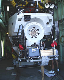 The submarine Alvin sits in its hanger onboard R/V Atlantis. The boxing gloves on Alvinâs manipulator protect people who are loading the basket from bumping their heads.
