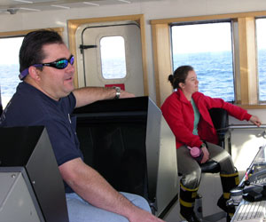 Kevin LeBouef, chief mate on the L. M. Gould, watches the sea, as Brenna McLeod, visiting the bridge, watches for the whales she studies. (Photo by Kate Madin, WHOI)