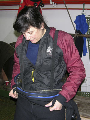 Drysuits are rubber, heavy, and difficult to pull on, and she begins in the hold, next to the ship's spare propeller blades. 
