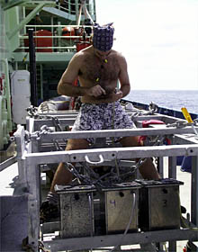Greg Kurras works on the Towed Camera Sled batteries. Each silver battery box contains a 6 volt DC golf cart battery that is immersed in oil to protect it from the great pressure at the seafloor. 
