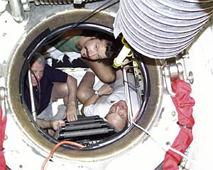 Gary Comer (left), BLee Williams the pilot (center) and Bob James look out of Alvin’s hatch as they complete their briefing session. 