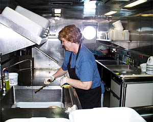 Virginia "Ginger" Crawford, the mess attendant, cleaning up in the galley. 
