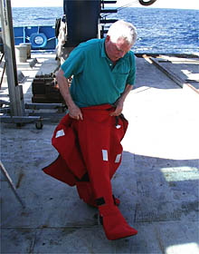 Gary Comer trying out a "Gumby" survival suit on the fantail. 