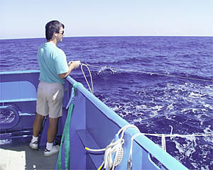 Patrick Hennessy tends the fishing lines on the stern of R/V Atlantis. 