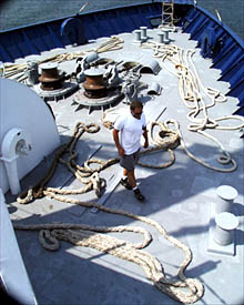 Chief Mate David Murline walks amid mooring lines lying on Melville’s bow after the ship is untied from the pier.