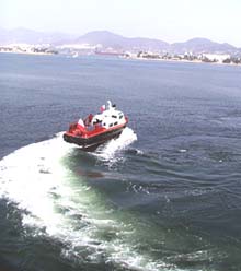 The harbor pilot boat pulls away after guiding Melville out of Manzanillo harbor. We're on our way. 