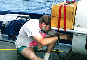 Expedition Leader Bob Elder makes last-minute adjustments to the tail-end of the DSL-120 sonar vehicle. The large yellow squares are pieces of syntactic foam that keep the heavy vehicle “neutrally bouyant” in the depths--so that it can float above the seafloor rather than sink to the bottom.