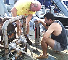 Ron Comer, Scripps’ resident technician, and Rob Palomares (right) attach a “pinger” to the DSL-120 depressor clump. The clump weight is attached to the same cable that tethers the DSL-120 to the ship. Most of the effects of the ship’s pitch and roll at the surface are dampened by the clump weight, giving the DSL-120 a more stable ride as it flies 100 meters above the seafloor. The pinger that Rob is holding send out a pulse of sound that bounces off the bottom to tell us how far the clump weight is above the seafloor. 