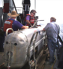 Bob Elder, PJ Bernard and Tom Crook (from left to right), all of Woods Hole Oceanographic Institution’s (WHOI) Deep Submergence Group, make one final check of the DSL-120 sidescan sonar before deploying it for the first survey.