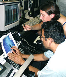 Clare Williams is responsible for plotting the positions of the ship and the DSL-120 sonar fish during her watch. She is discussing how the depth of the seafloor might change as the survey progresses with Rob Palomares, who is controlling the winch. Rob needs to know if the seafloor is rising or falling in front of the vehicle so that he can adjust the length of the towing cable to keep the sonar fish about 100 meters above the bottom.