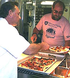 Dan Engelbrecht, the head cook on R/V Melville, serves pizza to Bob “Yogi” Elder at lunch. There is always something great to eat in the galley at every meal! 