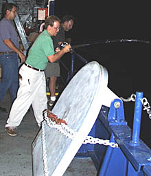 Erin Todd, a student from the University of Florida, hooks his own big tuna, while members of Melville’s crew watch. He is trying to reel it in before a shark, cruising a few meters away, can eat it first!