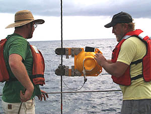 Randy Dickau (left) and Ron Comer clamp a relay transponder on the wire above a dredge that will be lowered to the seafloor. The transponder is the same one that we put on the DSL-120 sonar fish and Argo II, and is used with the seafloor navigation system to determine where the dredge is. See the “Oceanographic Tools” section in the “About the Cruise” part of the web site for more information about acoustic navigation and transponders. 