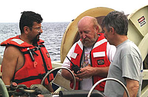 Rob Palomares (left), Ron Comer (middle) and Dan Fornari talk after recovering Argo II. The large drum in the background is the reel that contains the 11,000 meters of fiber optic cable on which the DSL-120 and Argo II are lowered to the seafloor. This is the cable that transmits all the signals and data from the vehicle up to the Control Van and to our waiting eyes. 