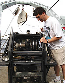 Dan Scheirer looks at Argo II after it has been tied down on the deck of R/V Melville. When equipment is lowered into the water, the wire is lead through one of the large round sheaves (or pulleys) in the background. 