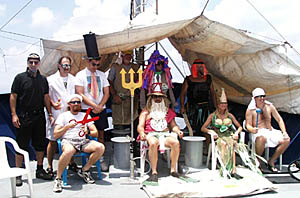 King Neptune and His Royal Court convene for the Equator Line Crossing. Standing (left to right): Mike Perfit (The Royal Prosecuting Attorney), Craig Elder (The Royal Doctor), Dan Scheirer (The Public Defender), Bill Kamholz (The Sheriff), Capt. Eric Buck (The Royal Hoser), Ron Comer (The Sea Hag). Sitting from left to right: Scott White (The Royal Barber), King Neptune (Bob “Yogi” Elder), Uta Peckman (the Queen), and Paul Johnson (The Royal Baby). 