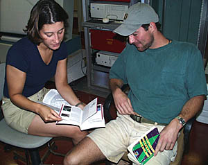 Clare Williams and Tim Haskell look over the travel and information books on the Galapagos Islands -- we will be arriving there tomorrow! 