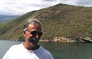 Mike Perfit with the south side of Tagus Cove in the background. Note the layered rocks in the cliff just above his head and to the right. See the previous photo for an explanation.