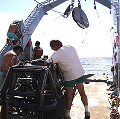 Bob “Yogi” Elder (right) does a post-dive check of the equipment on Argo II after it was brought back on board the ship this afternoon. Rob Palomares, the Scripps CTD technician (left), removes the MAPR from the Argo II frame so that he can start downloading the data. Our next operation is dredging. In preparation for this, Ron Comer (on the A-frame) feeds the dredge wire through the smaller sheave. Randy Dickau is standing by to assist Ron in setting up the dredge. 