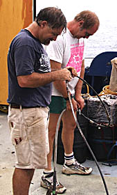 PJ Bernard (left) and Bob “Yogi” Elder take apart the end, or termination, of the fiber optic cable in preparation for packing up the vehicle and winch systems.