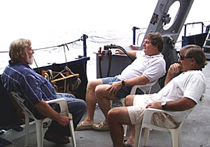 Tom Crook (left), Steve Gegg (middle) and PJ Bernard relax by the starboard rail of R/V Melville as we head towards port.