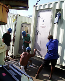 Crew members help to guide the container on to the ship.  