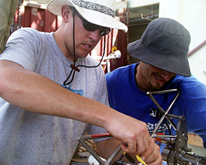  DSOG techs Peter Collins (left) and Fran Taylor secure a water sampler to the elevator before it returns to the seafloor. 