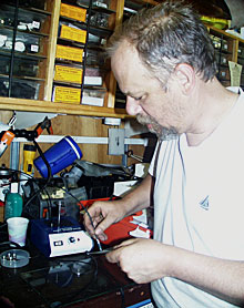 Chief Pilot Will Sellers polishes one of the tiny glass fibers in the tether cable that connects ROV Jason to Medea.  