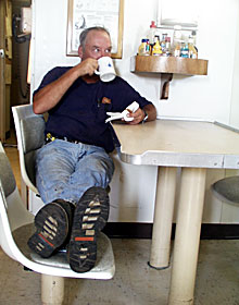 Bosun Alan Hopkins takes a morning coffee break in the galley. (Al wishes his wife, Ginny, a happy fourth wedding anniversary).  