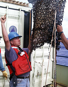 Bosun Al Hopkins directs Seaman Mike Doherty, the crane operator, during the dredge’s launch.  