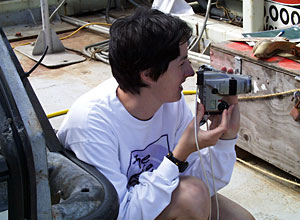 Science writer Amy Nevala photographs geologists recovering the rock dredge on the fantail of R/V Knorr.  