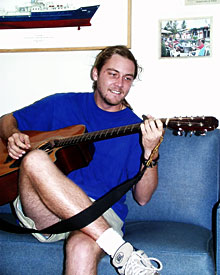 Graduate student Robbie Young takes a break for guitar practice in the ship’s galley.  