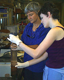 Microbiologist Anna-Louise Reysenbach and Biology Student Jessie Philley use a plunger to extract the sediment core from the clear plastic cylinder.  