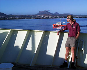Chief Mate Kent Sheasley stands watch on the bow of the ship. The red-and-white pilot boat met Knorr outside Port Louis and accompanied us into port.  