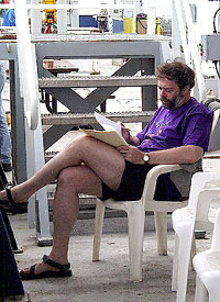Alberto Saal catches up on some paper reading out on deck. 