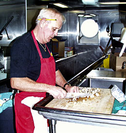  Edward Miller, the Senior Cook, chops mushrooms as he prepares one of the day’s meals. 
