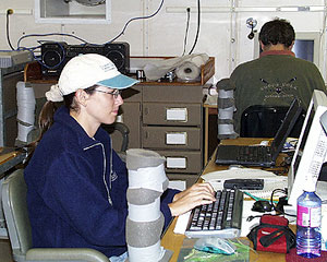 Christy Reed, the Dive and Discover science writer for this expedition preparing today’s daily journal at her desk in the Main Lab. 