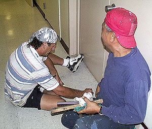  Billy Wells (left), Wiper, and Reynaldo Esteban, Oiler, fix floor sockets in the corridor. These sockets are threaded and permit us to bolt down equipment in the labs on Revelle. 