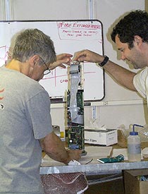 Dan Fornari (left) and Josh Curtice inspect the pressure housing of a component of the digital deep sea camera.