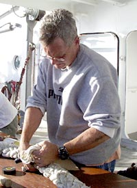 Tim Hill, Able Seaman, finishes splicing a mooring line.  