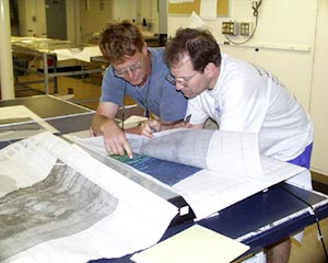 Denny Geist (left) and Mark Kurz look over bathymetric and MR1 sonar maps of the area we are working in. They are deciding on the best places to dredge.  
