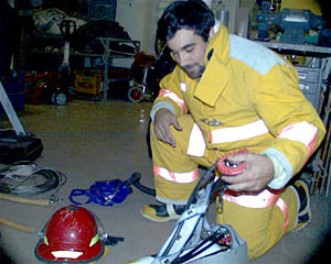 Joe Ferris, Third Mate, during a fire drill. He is demonstrating how to don a fire-fighting suit and handle the extinguishers.  