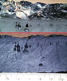  Two views of a slab of pillow basalt recovered on Dredge 22A from the submarine east rift of Genovesa Island. In the top view, note the shiny glassy crust that forms immediately when the lava is erupted on the seafloor. In the bottom view, note the small holes, called vesicles, that form during the eruption as the gases in the magma escape.  