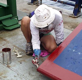 Lorna Allison, Ordinary Seaman, puts a coat of rust primer on the one of the ship’s side panels. 