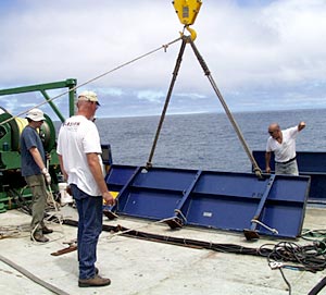  Bent back into shape, chipped and re-painted - the port bullwark was finally moved into place on the fan tail. Eric Wakeman (left), Chief Mate, Ron Wheatley, Chief Engineer, and Victor Barnhart, Bosun use the ships cranes to move the large panel. 