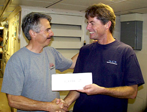  Dan Fornari accepts the runner-up prize for the ping-pong tournament from Captain Chris Curl. 