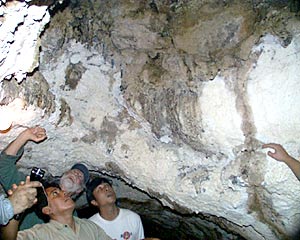 Steve Tottori and Dan Jacobson inspect the ceiling of a lava tube on the summit of Santa Cruz volcano. Lava tubes form by lava flowing down the flanks of volcanoes through underground conduits that later drain when the eruption subsides. This lava tube is called “Cave of the Pirates.” 